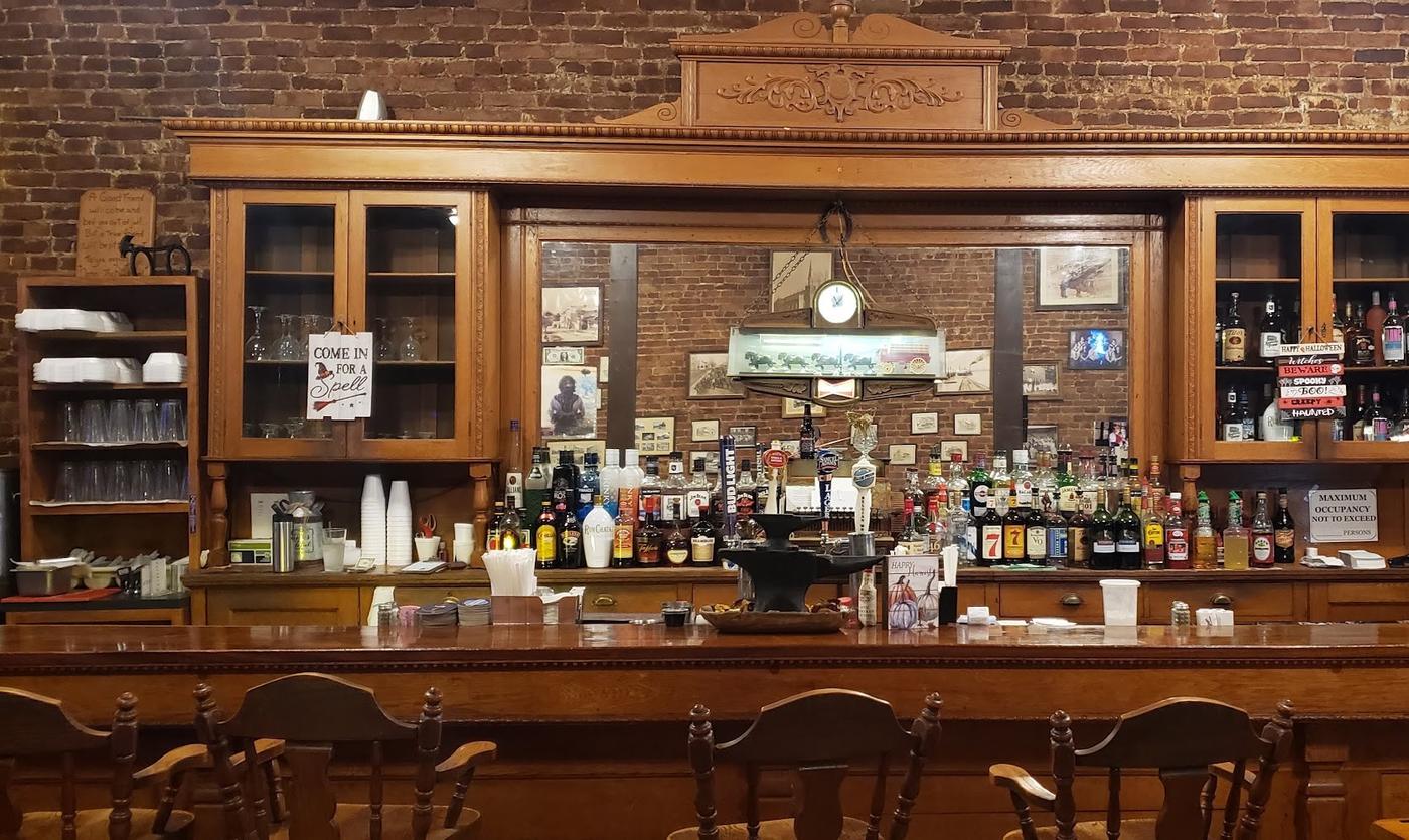 The tall carved back bar at the Anvil Saloon, with a blacksmith's anvil standing on the bar top