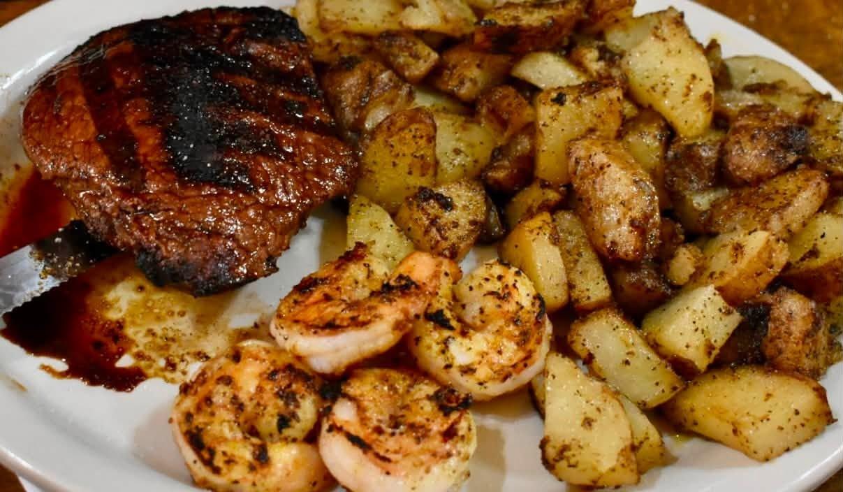Steak with grilled shrimp and German fries